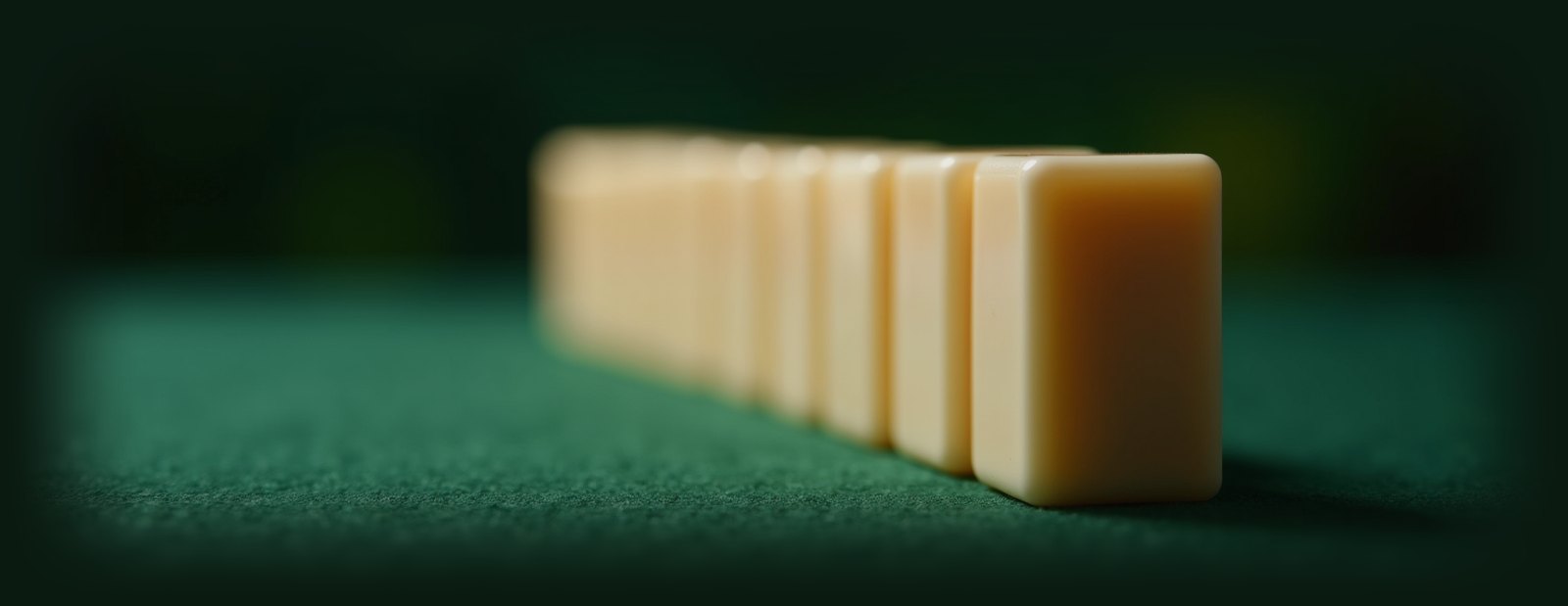 Mahjong tiles lined up on green felt